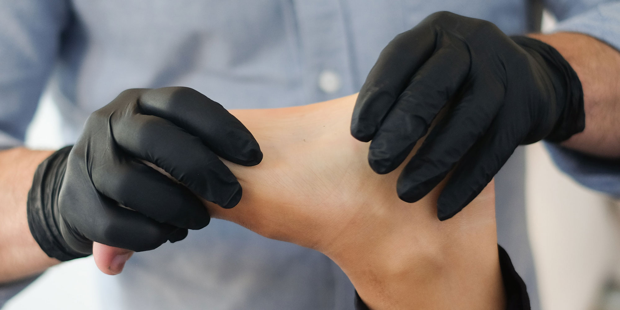 physiotherapist treating patient by manipulating foot